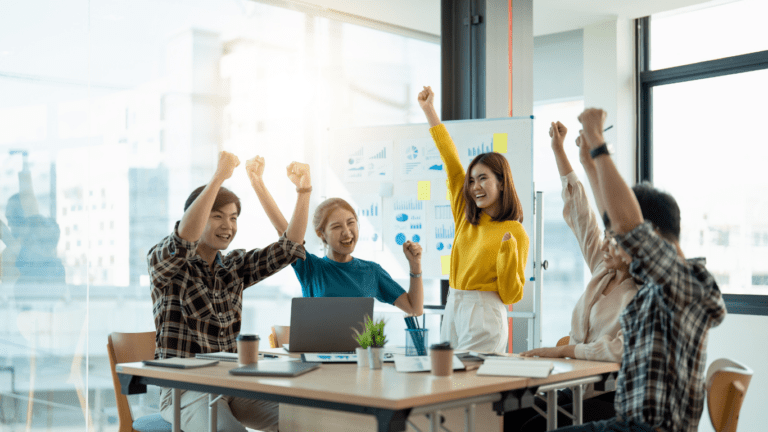 a group of business people raising their hands in the air