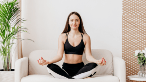 a person is sitting on a couch and doing yoga