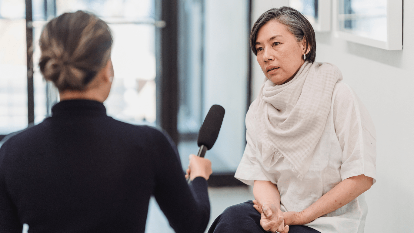 A woman is interviewed by a reporter.