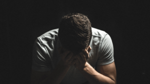 a person sitting with their hands on their face