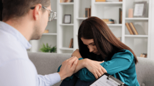 A person and another person sitting on a couch