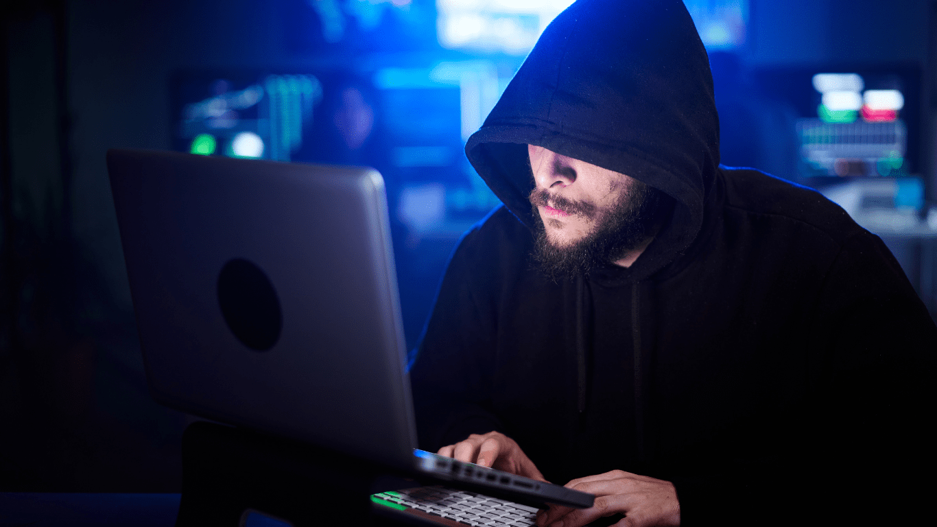 a person in a hoodie is working on a laptop